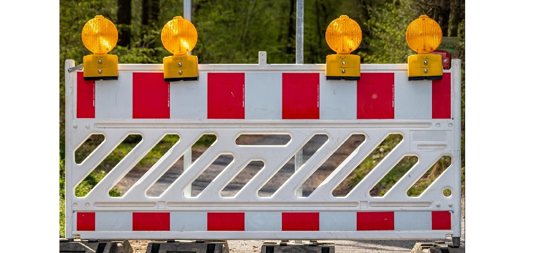 weiße Absperrung mit orangenen Signalleuchten