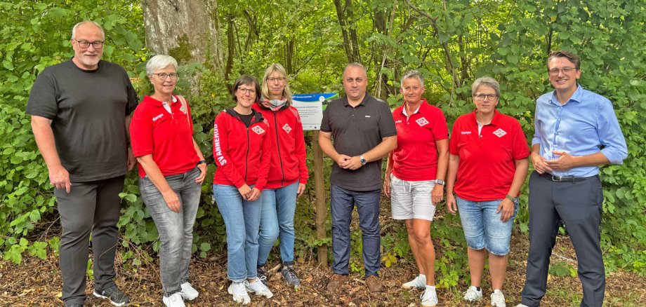Sportdezernent Christopher Lipp (r.) hat gemeinsam mit Fernwalds Bürgermeister Manuel Rosenke (M.) und Thorsten Bücking (l.) den neuen ATP-Bewegungspfad offiziell eröffnet. Unterstützt wird das neue Sportangebot von den Mitgliedern des Sportvereins Annerod e.V. (Foto: Landkreis Gießen)